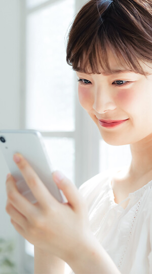 スマホからLINE予約をする女性