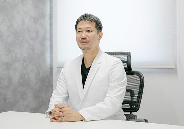 デスクにて質問に答えている院長の画像
