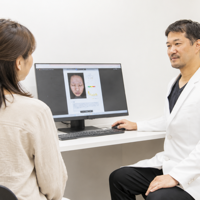 美容皮膚科で患者とカウンセリングをする男性医師