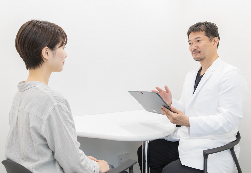 美容皮膚科で患者とカウンセリングする男性医師