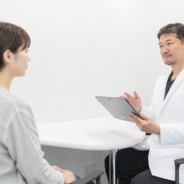 医師が患者に向け、施術方針のカウンセリングをしている様子